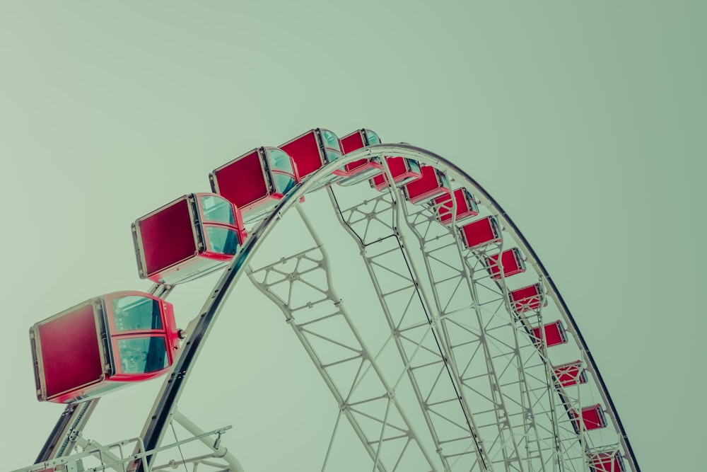 a red and white ferris wheel against a gray sky