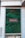 A vertical garden is integrated into the facade of a building, featuring lush green foliage. A rectangular sign with white script is centrally positioned on the garden wall. The exterior is made of light-colored stone tiles, complementing the natural green hues of the plants.