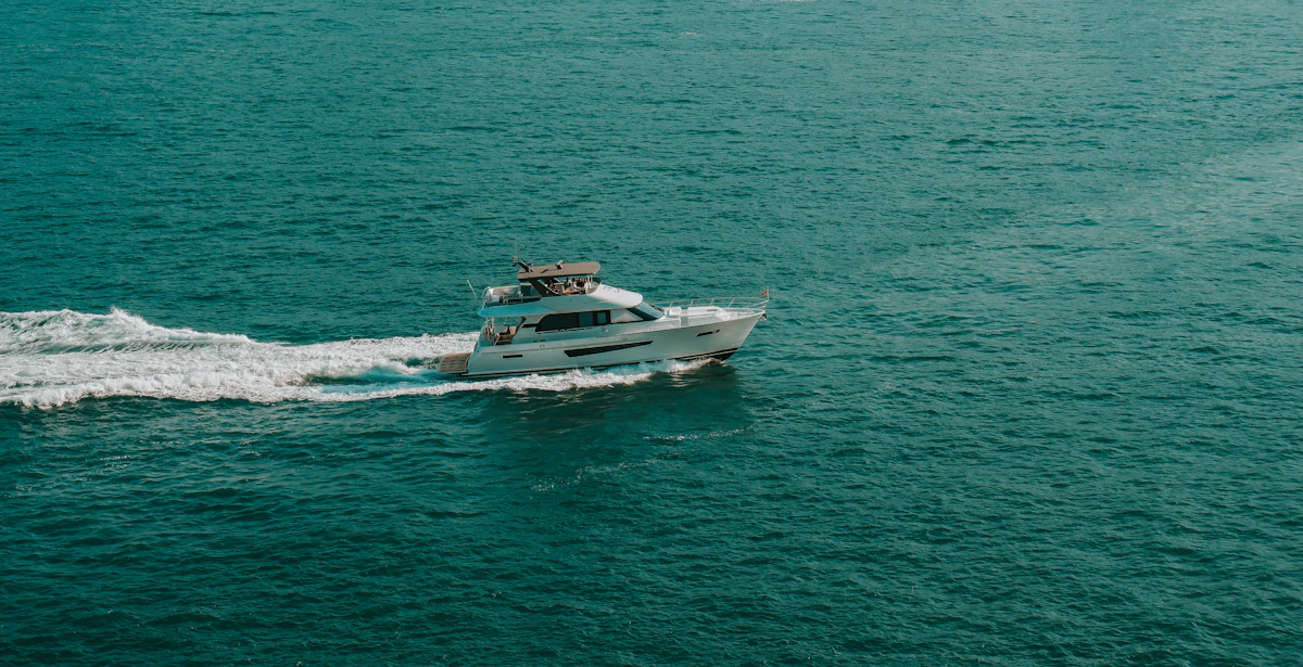 A white motorboat crossing open blue water