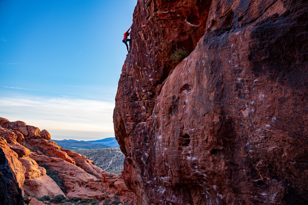 a man climbing up the side of a mountain