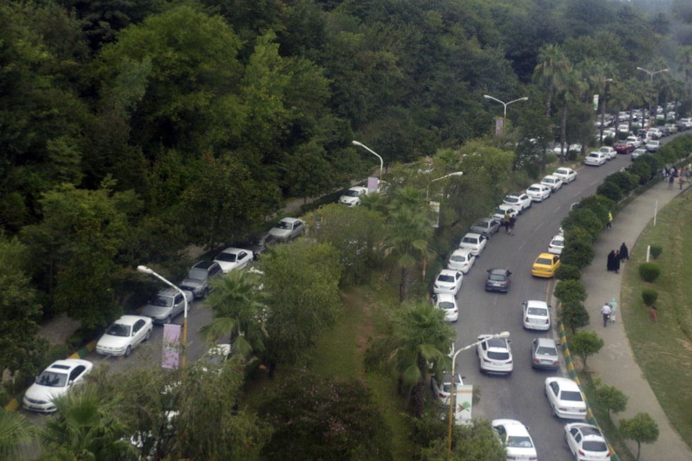 a bunch of cars that are parked on the side of the road