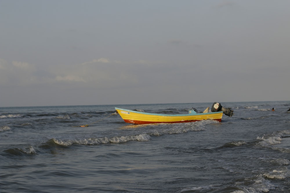 a small yellow boat floating on top of a body of water