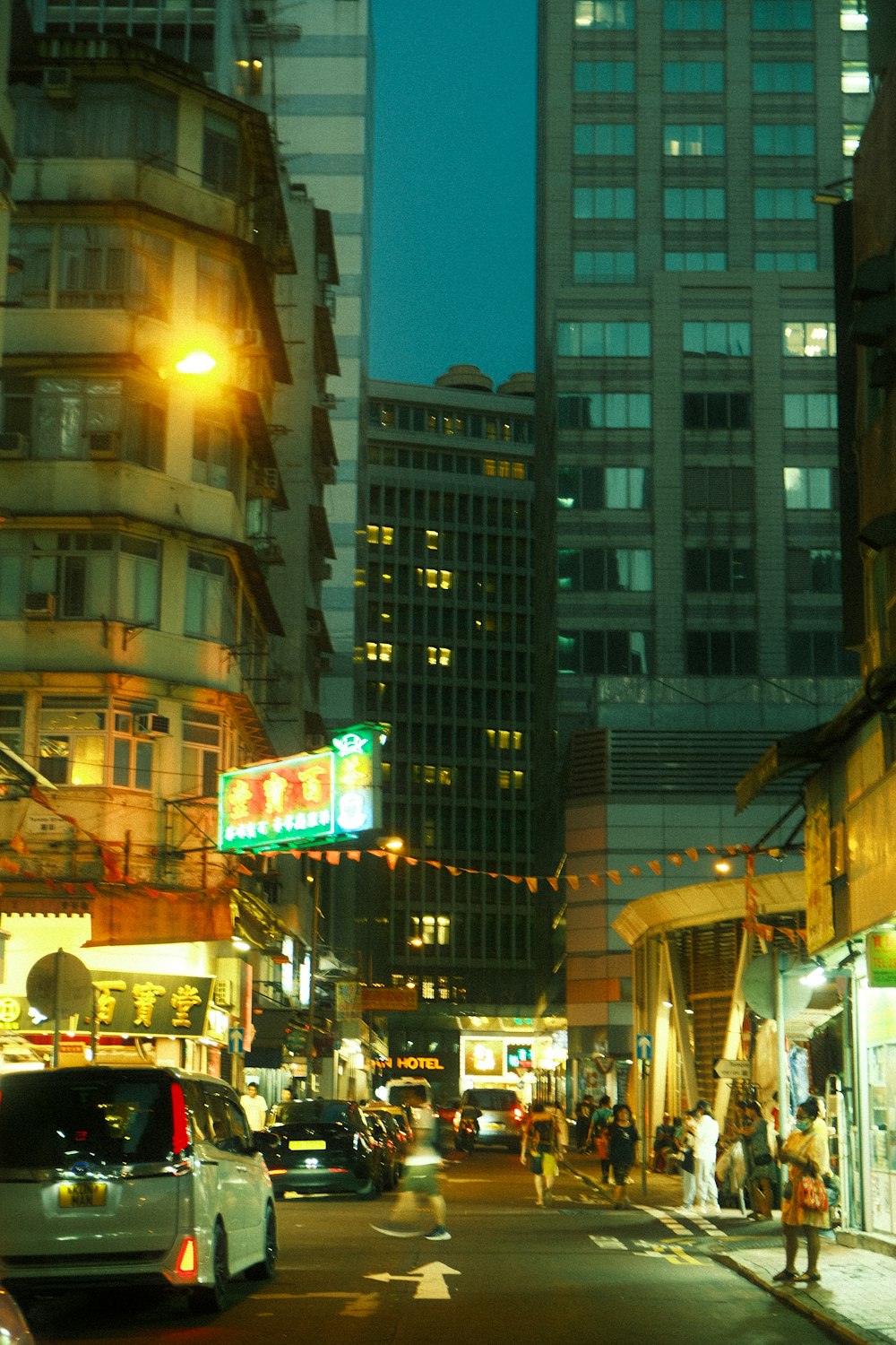 a busy city street at night with tall buildings