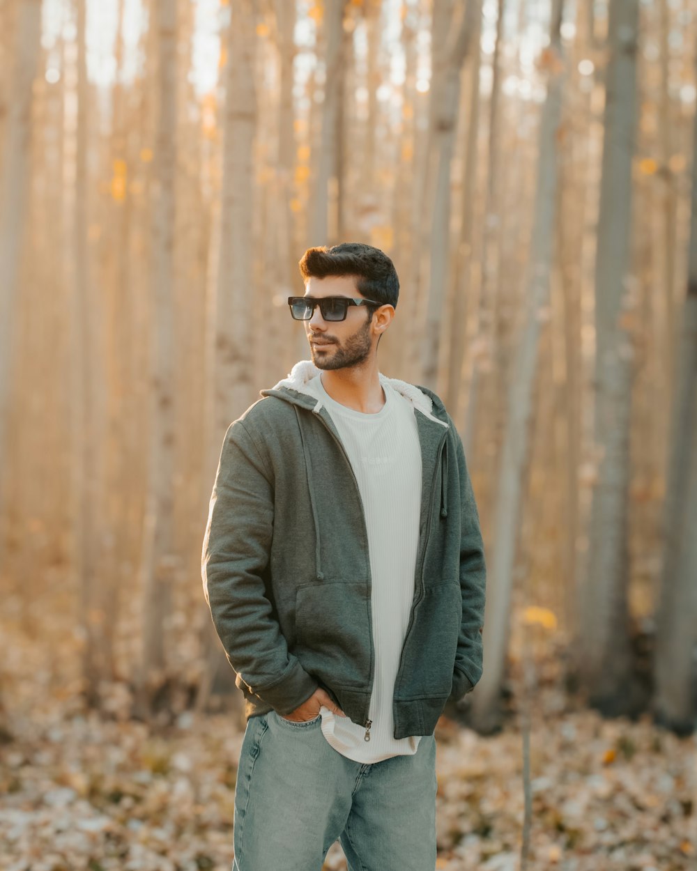 a man standing in front of a grove of trees