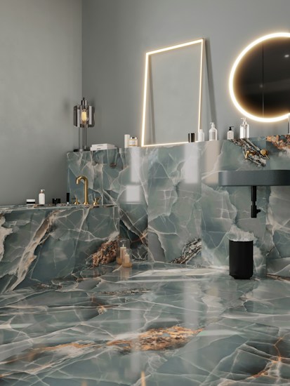 A modern bathroom features luxurious green and white marble surfaces throughout, including the walls, countertop, and floor. There is a rectangular mirror with a soft glow of LED lighting surrounding it and a circular mirror emits a warm ambient light. The gold fixtures, including a faucet, add an elegant touch. Various bottles and toiletries are neatly arranged on the countertop. The overall design is sleek and sophisticated.
