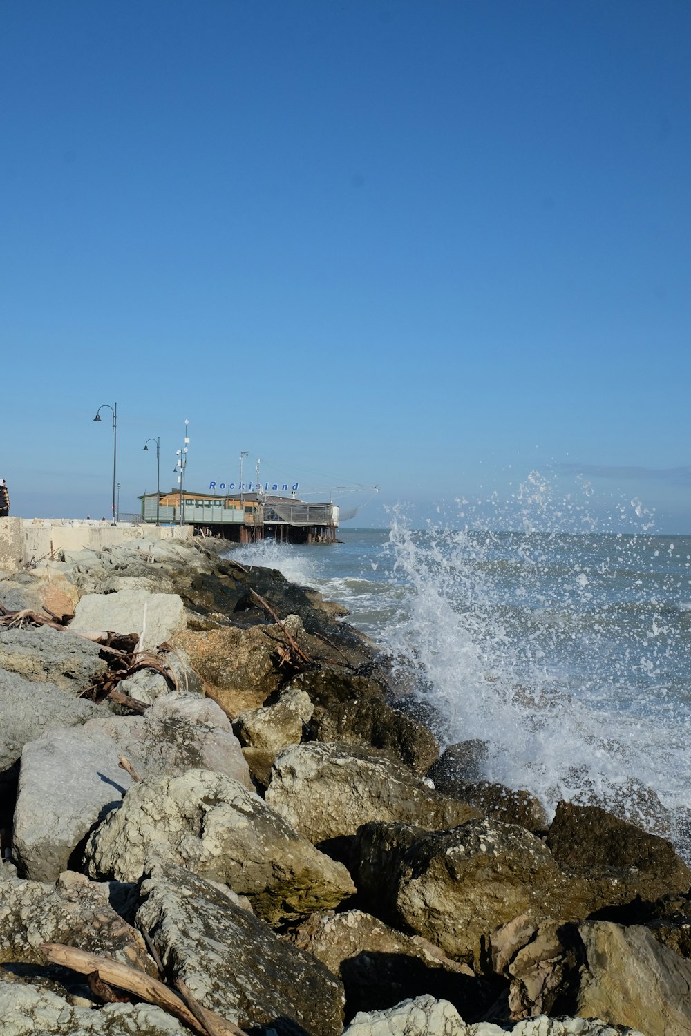 a rocky beach with a pier in the background