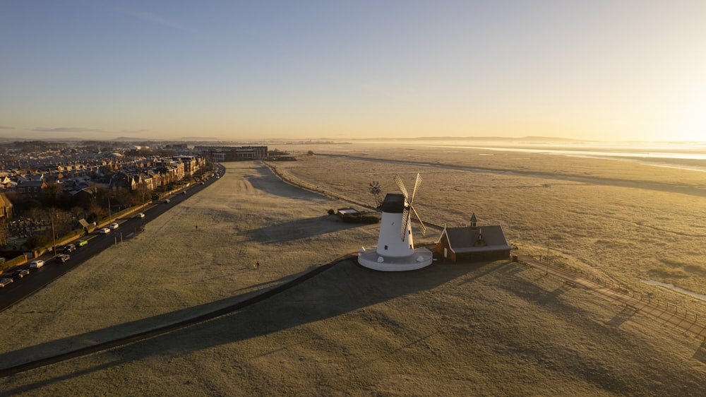 an aerial view of a windmill in the middle of a field