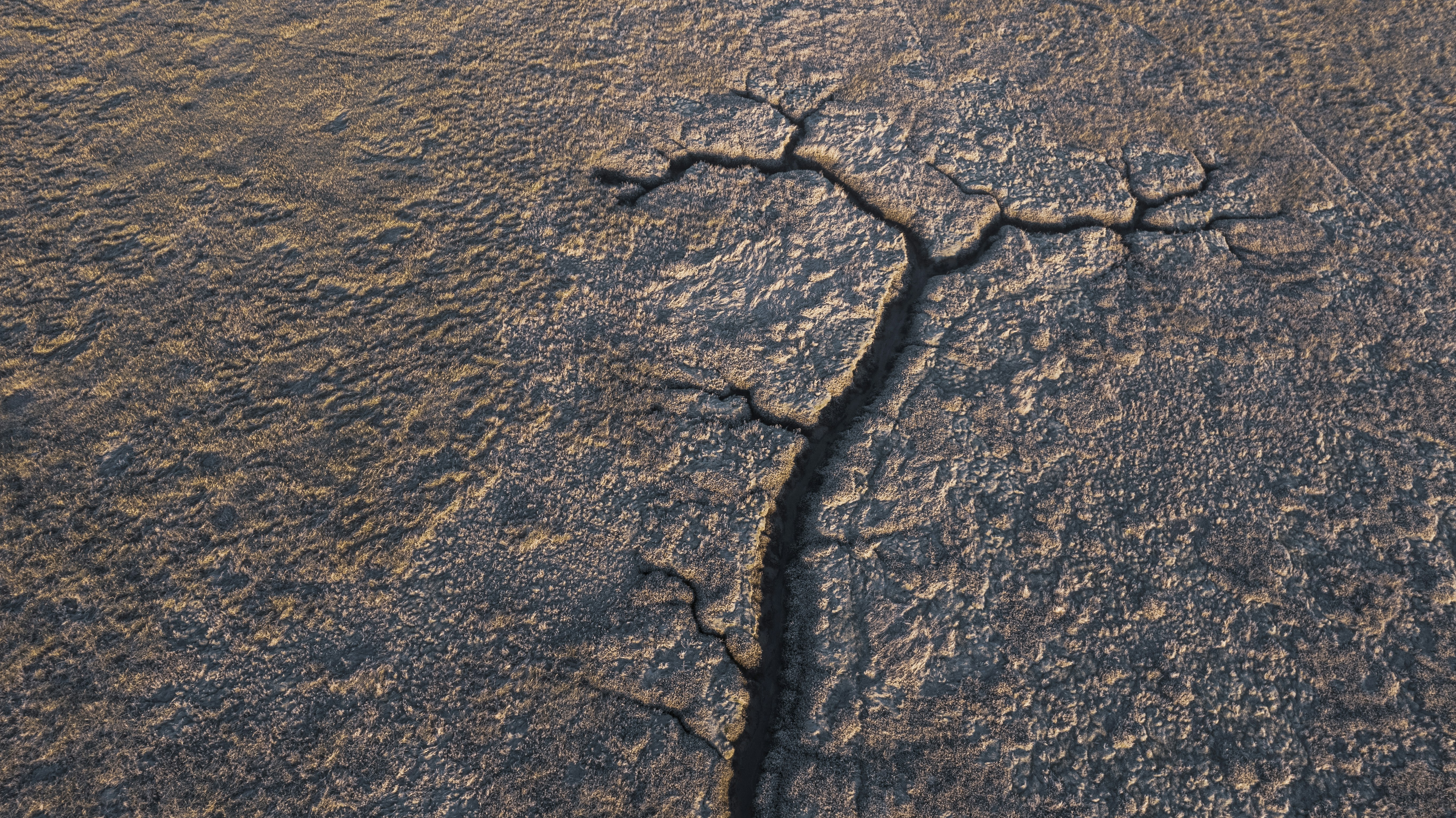 a crack in the ground in the middle of the desert