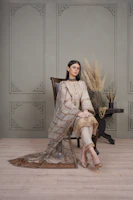 Close-up of elegant nagra shoes and a gold-accented dupatta draped over a wooden chair.