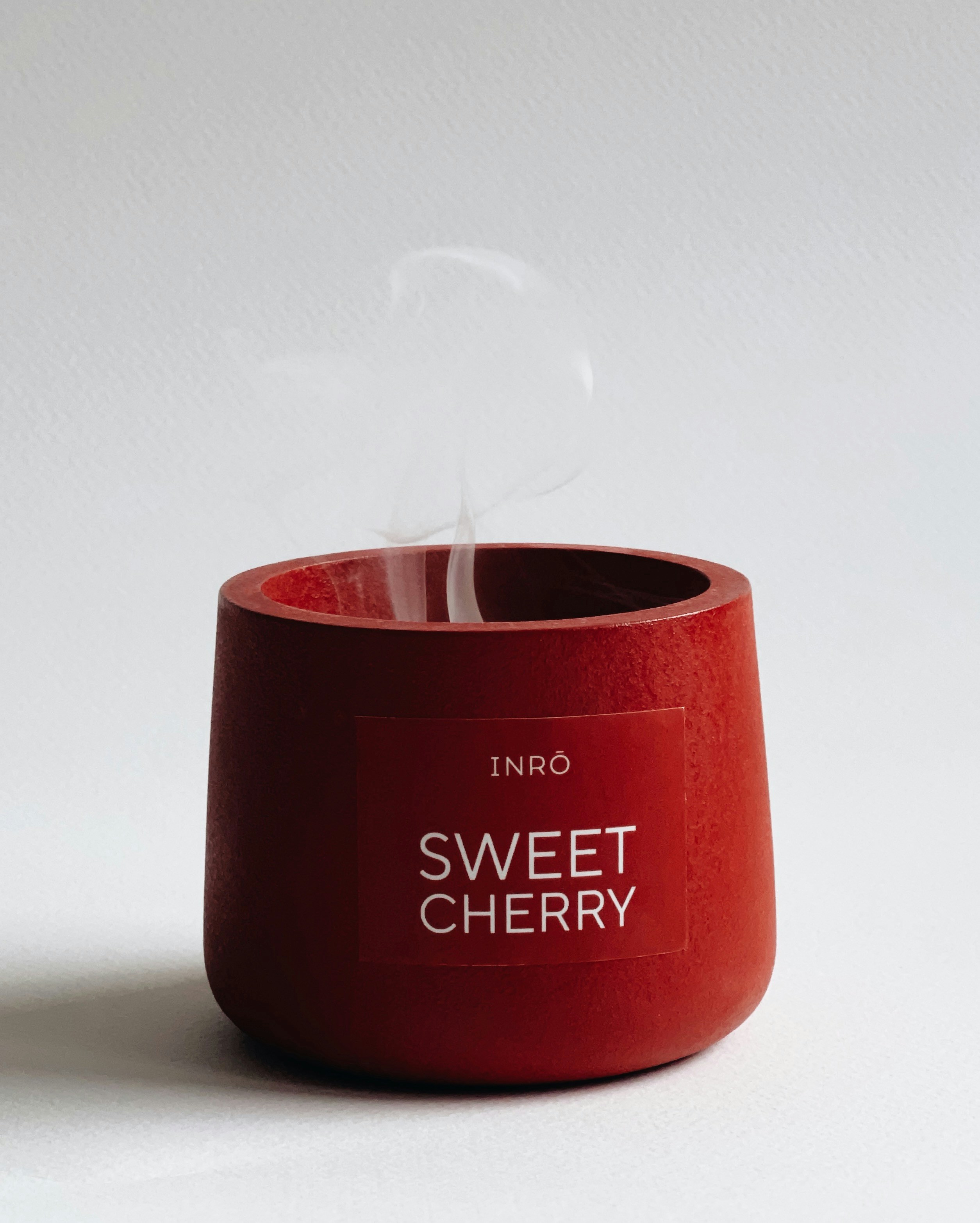 um copo vermelho sentado em cima de uma mesa branca