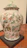 Close-up of a delicate porcelain vase with intricate hand-painted floral designs.