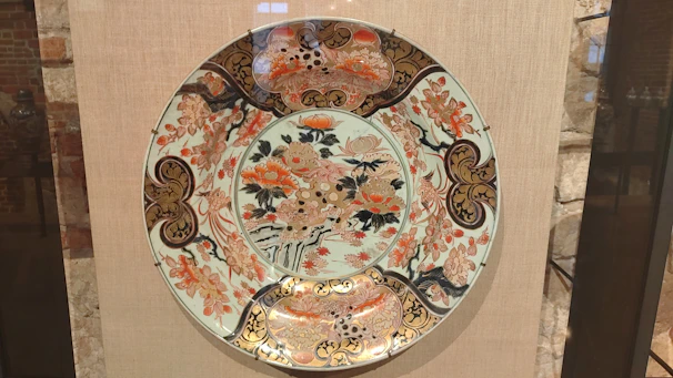 Elegant hand-painted ceramic plate with intricate Ottoman floral motifs in warm earthy tones.