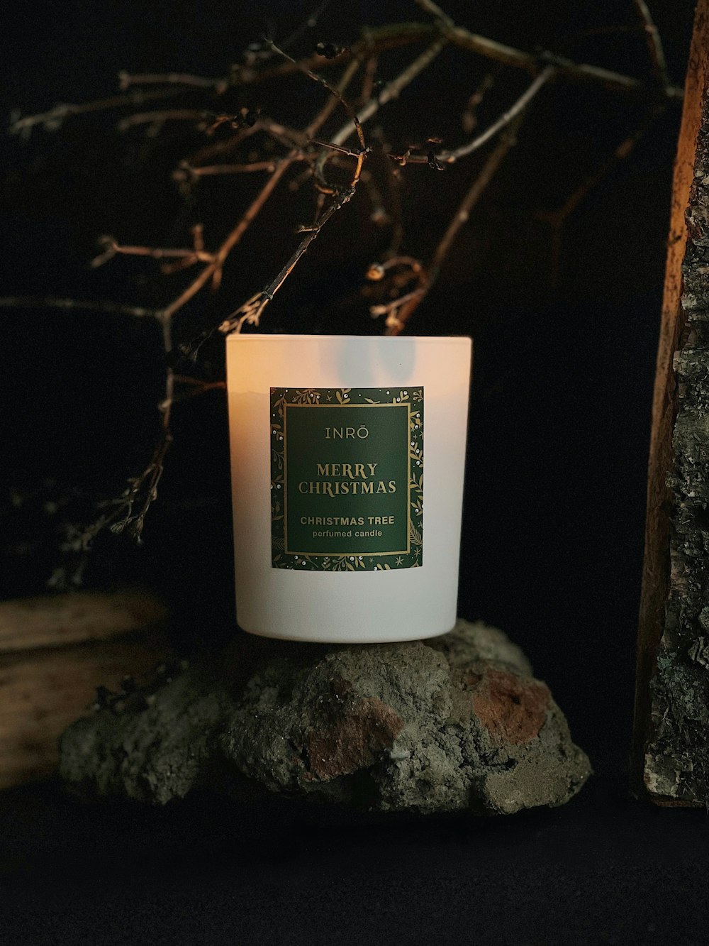 a white candle sitting on top of a rock