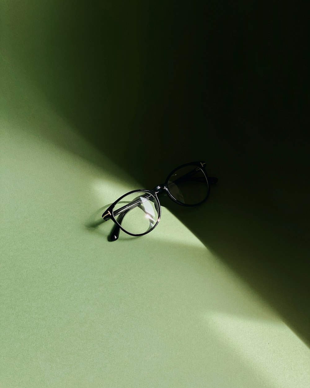 a pair of glasses laying on a green surface