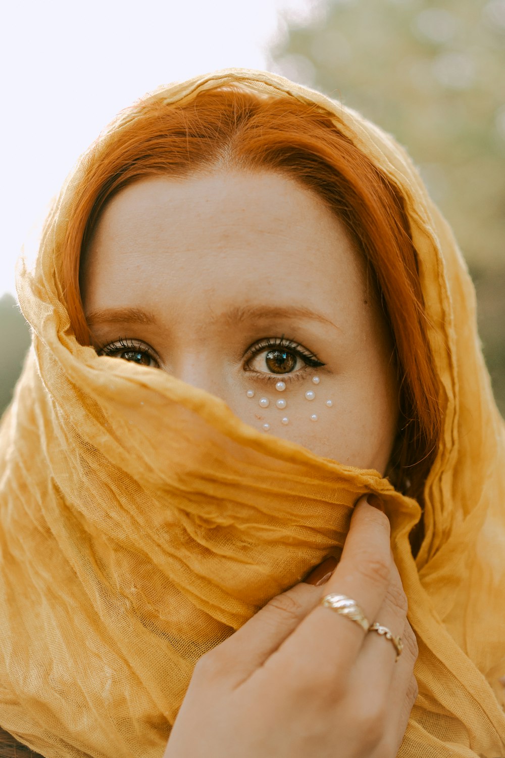 uma mulher usando um lenço amarelo cobrindo o rosto