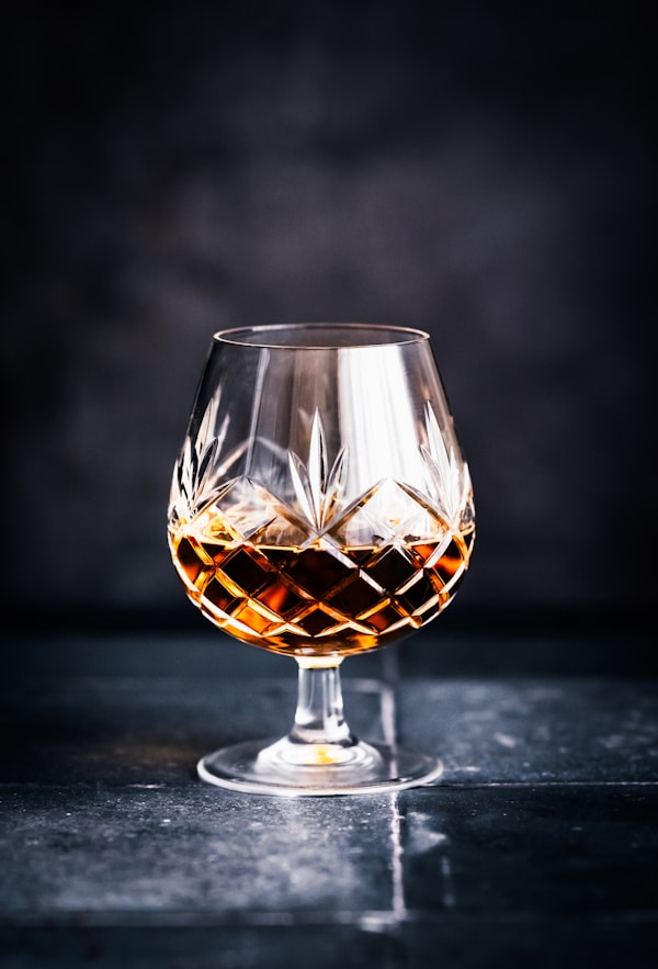 A glass of whiskey sitting on top of a table