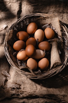 a basket filled with brown eggs on top of a table