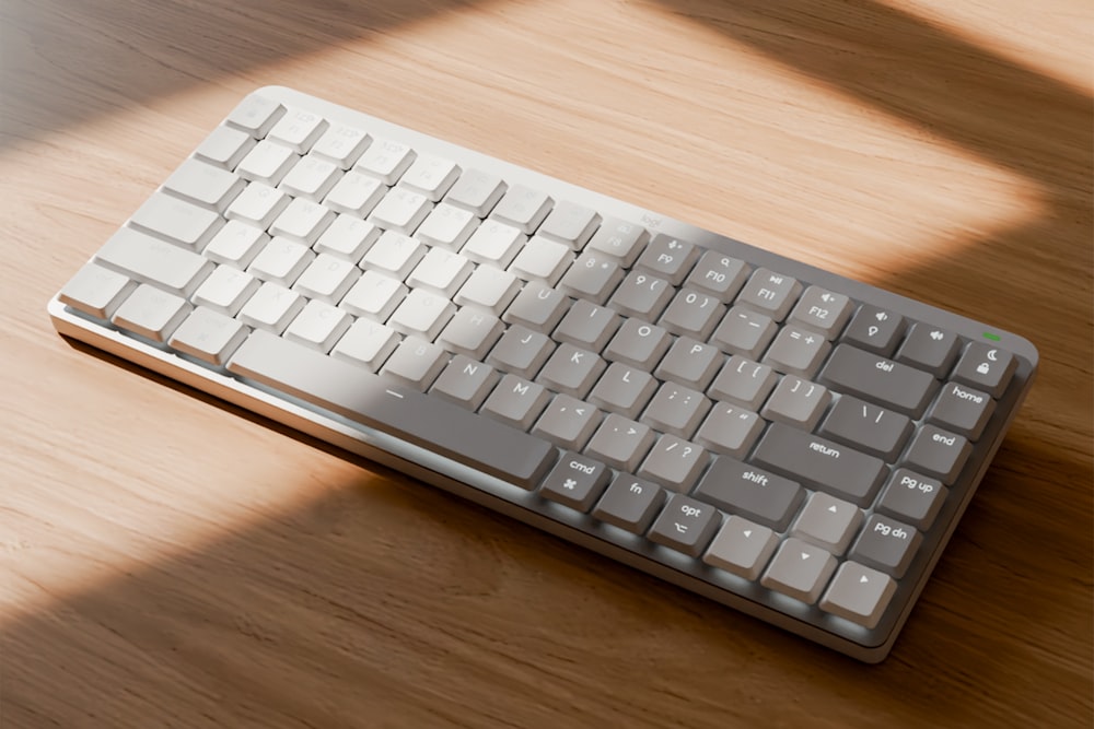 a computer keyboard sitting on top of a wooden table