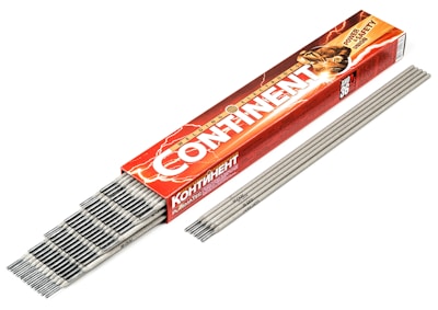A red and orange box with the text 'CONTINENT' contains an array of gray welding electrodes. The box features a graphic of a person welding, with sparks visible. The electrodes are laid out neatly beside the box.