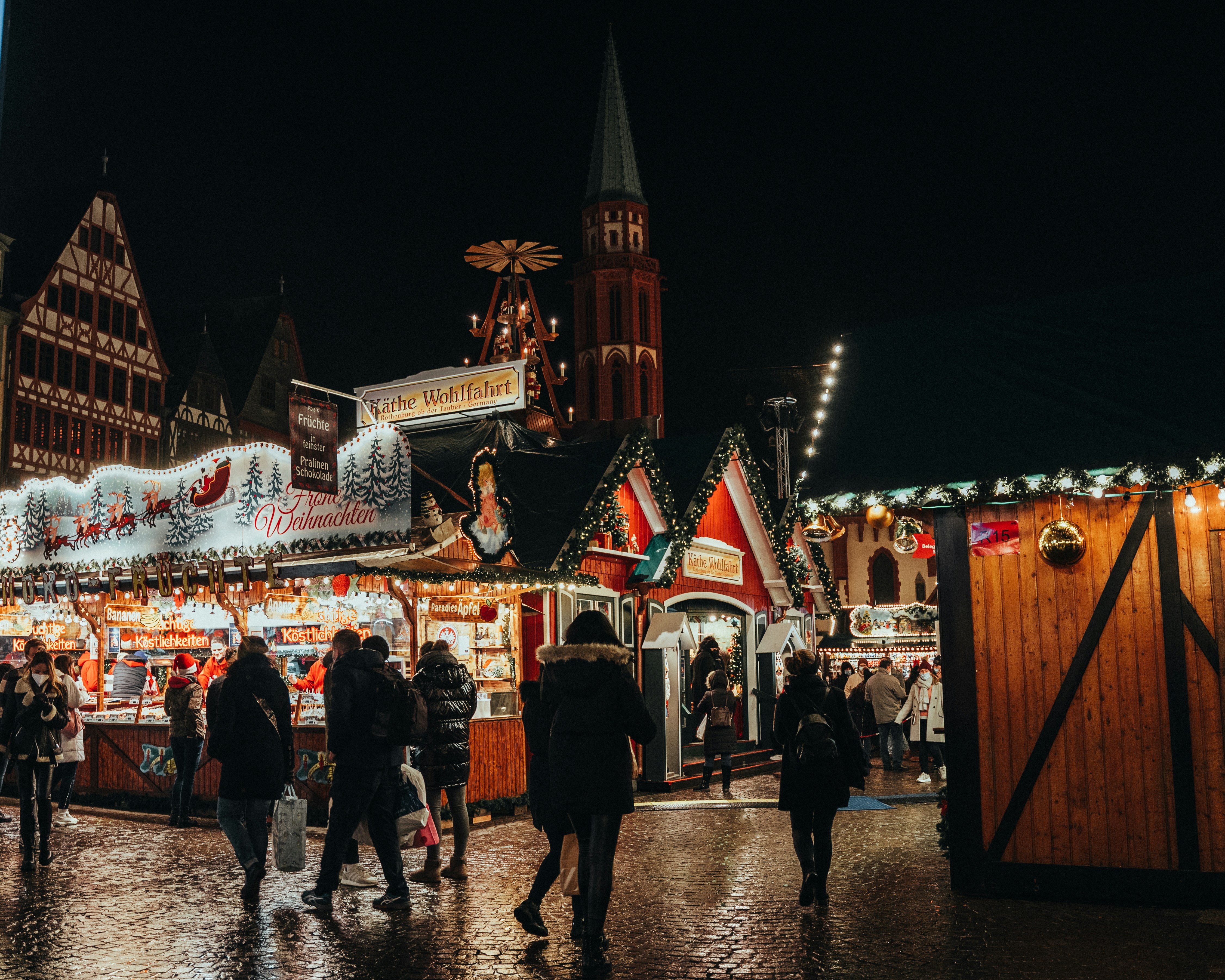 a group of people walking around a christmas market