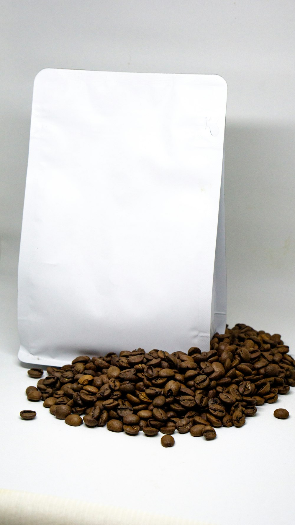 a bag of coffee beans next to a pile of coffee beans