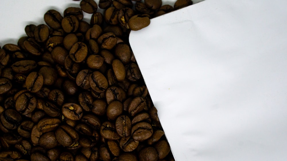 a pile of coffee beans next to a white paper