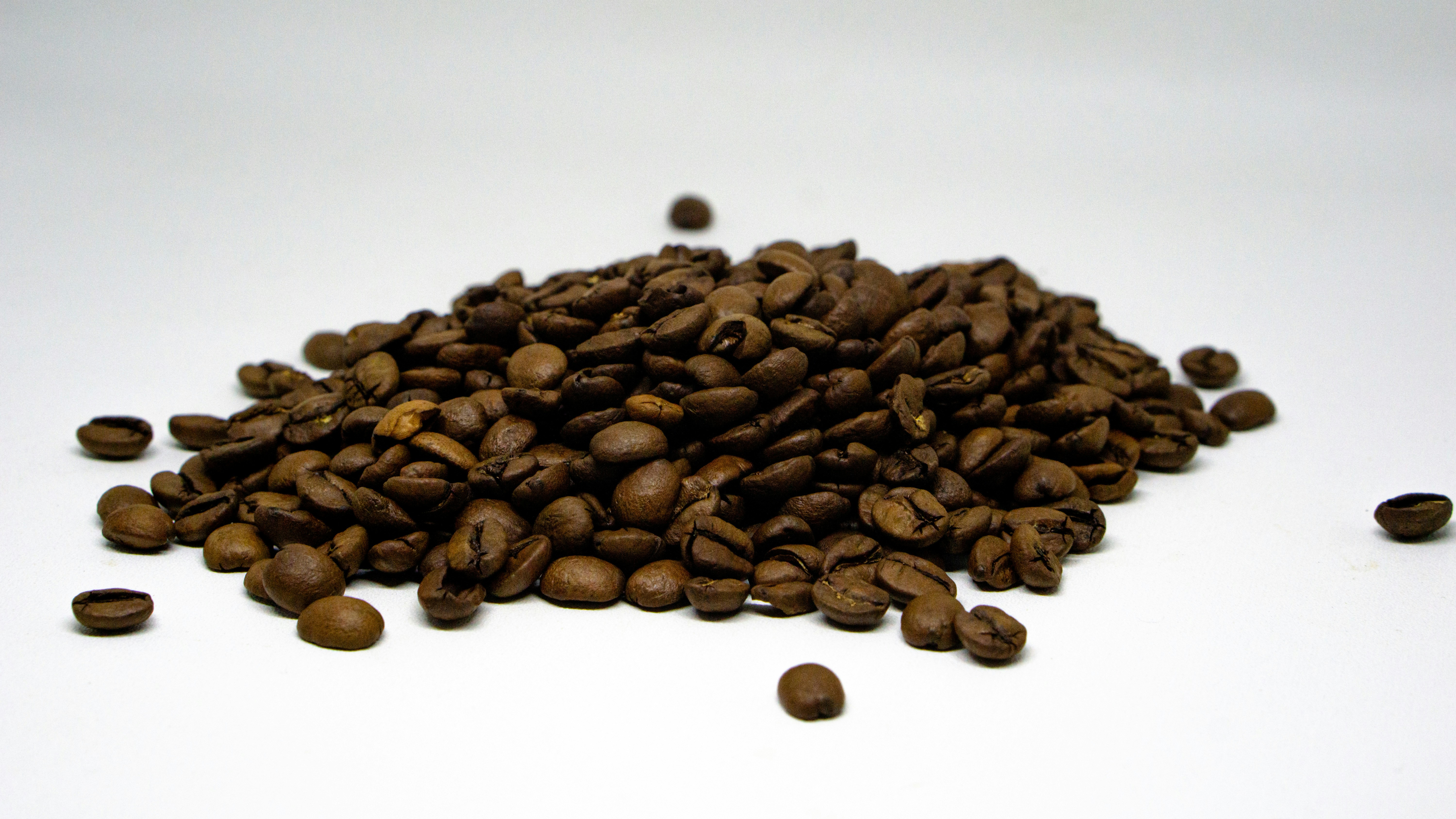 a pile of coffee beans sitting on top of a white table