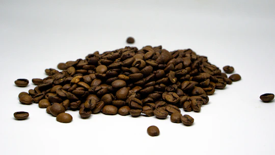 a pile of coffee beans sitting on top of a white table
