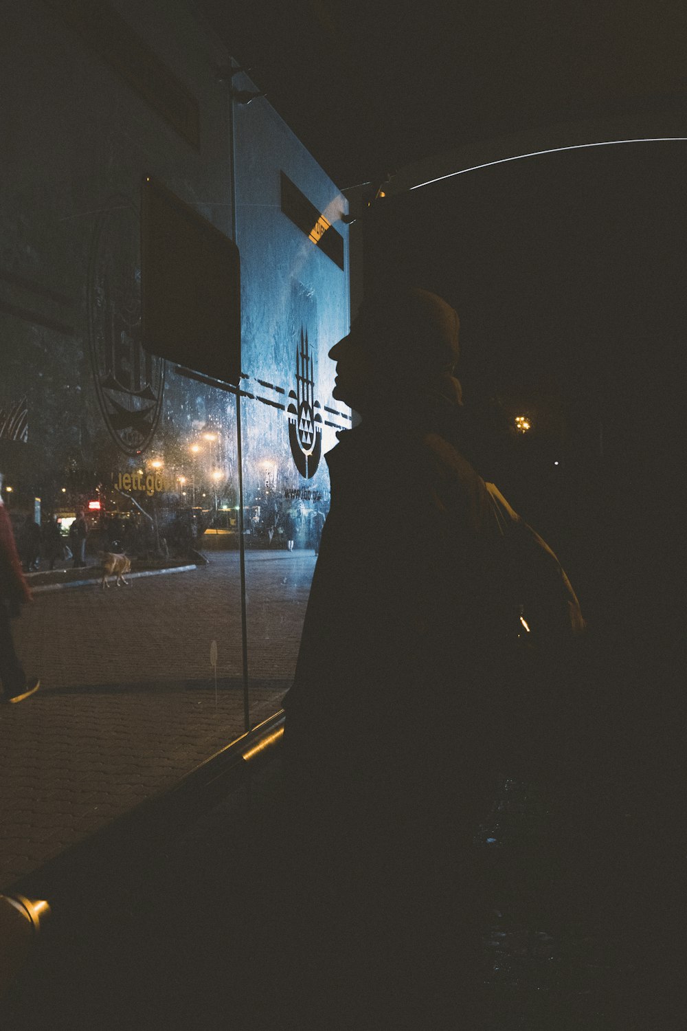 a man standing in front of a window at night