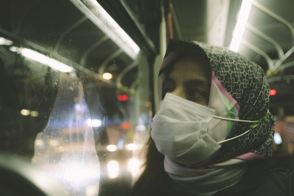 a woman wearing a face mask on a bus