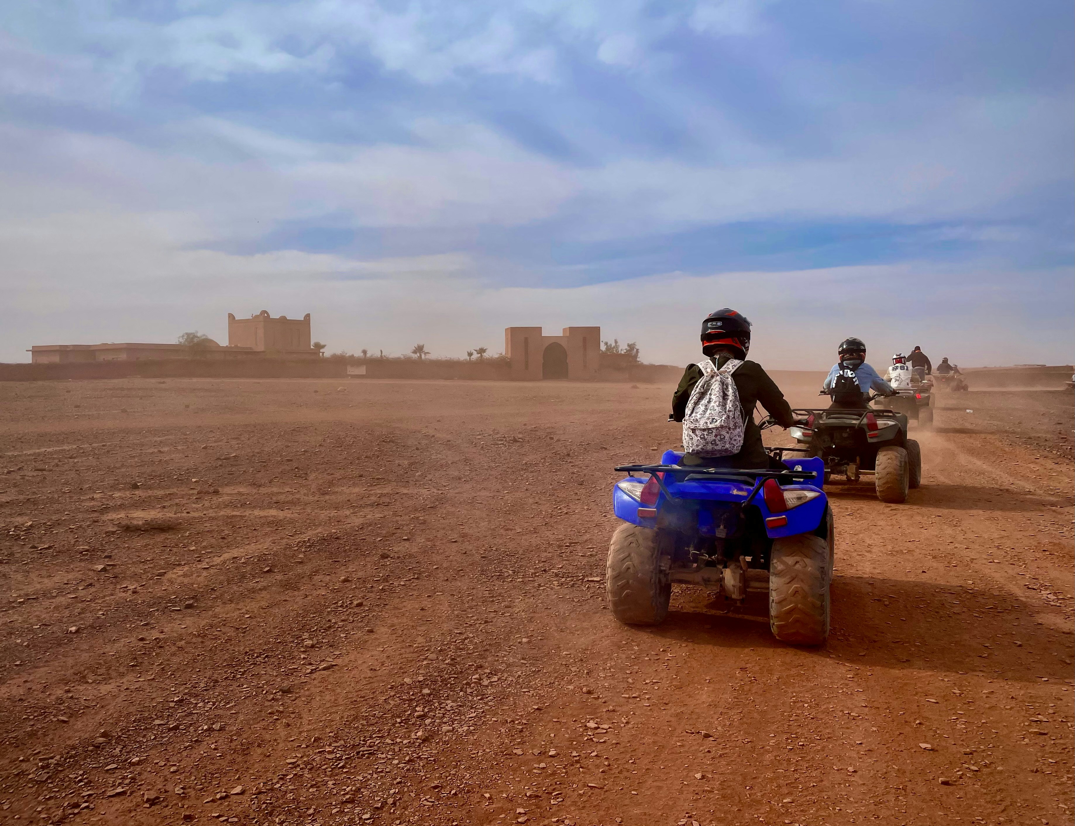 a group of people riding four wheelers on a dirt road