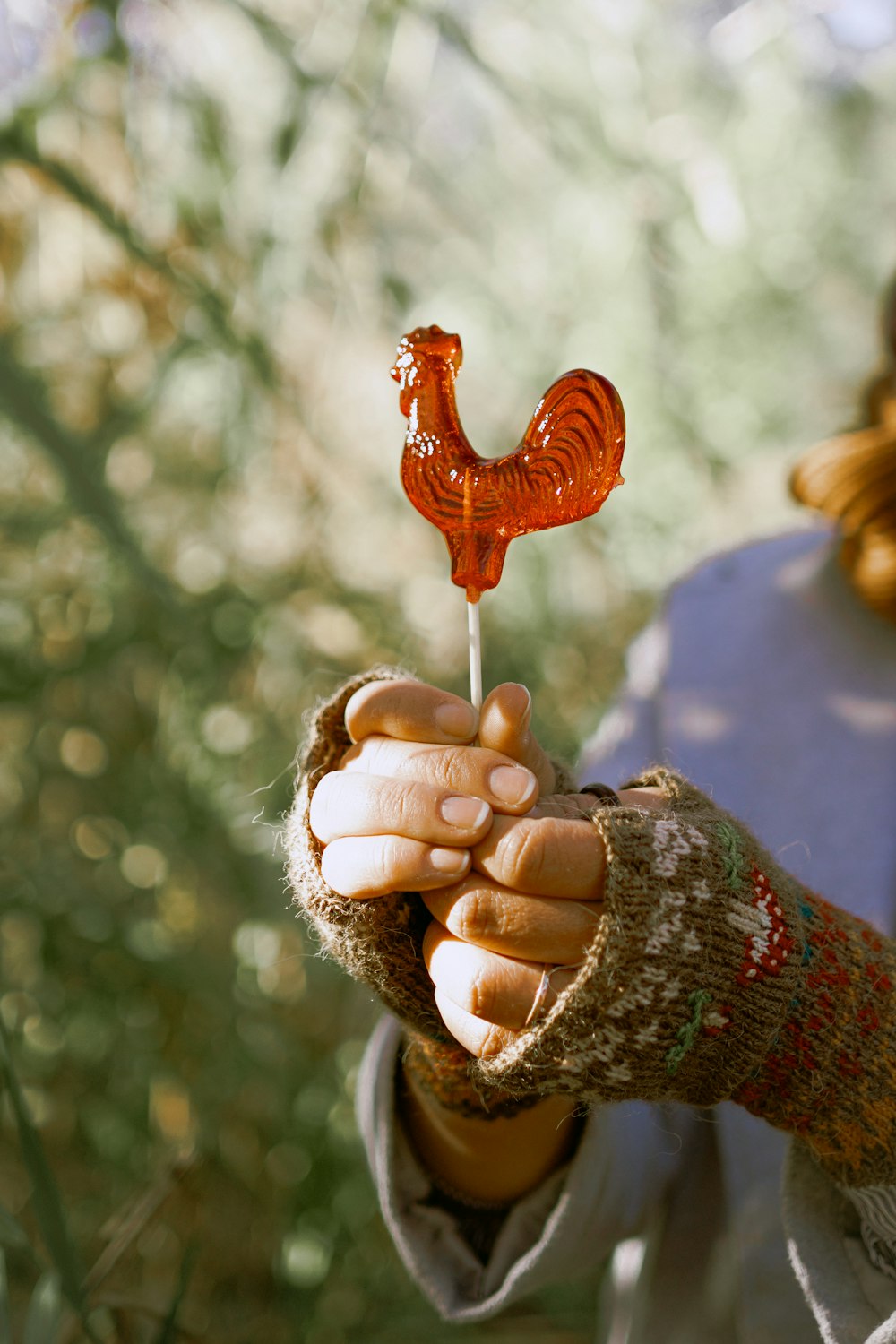 a woman is holding a small red object in her hands