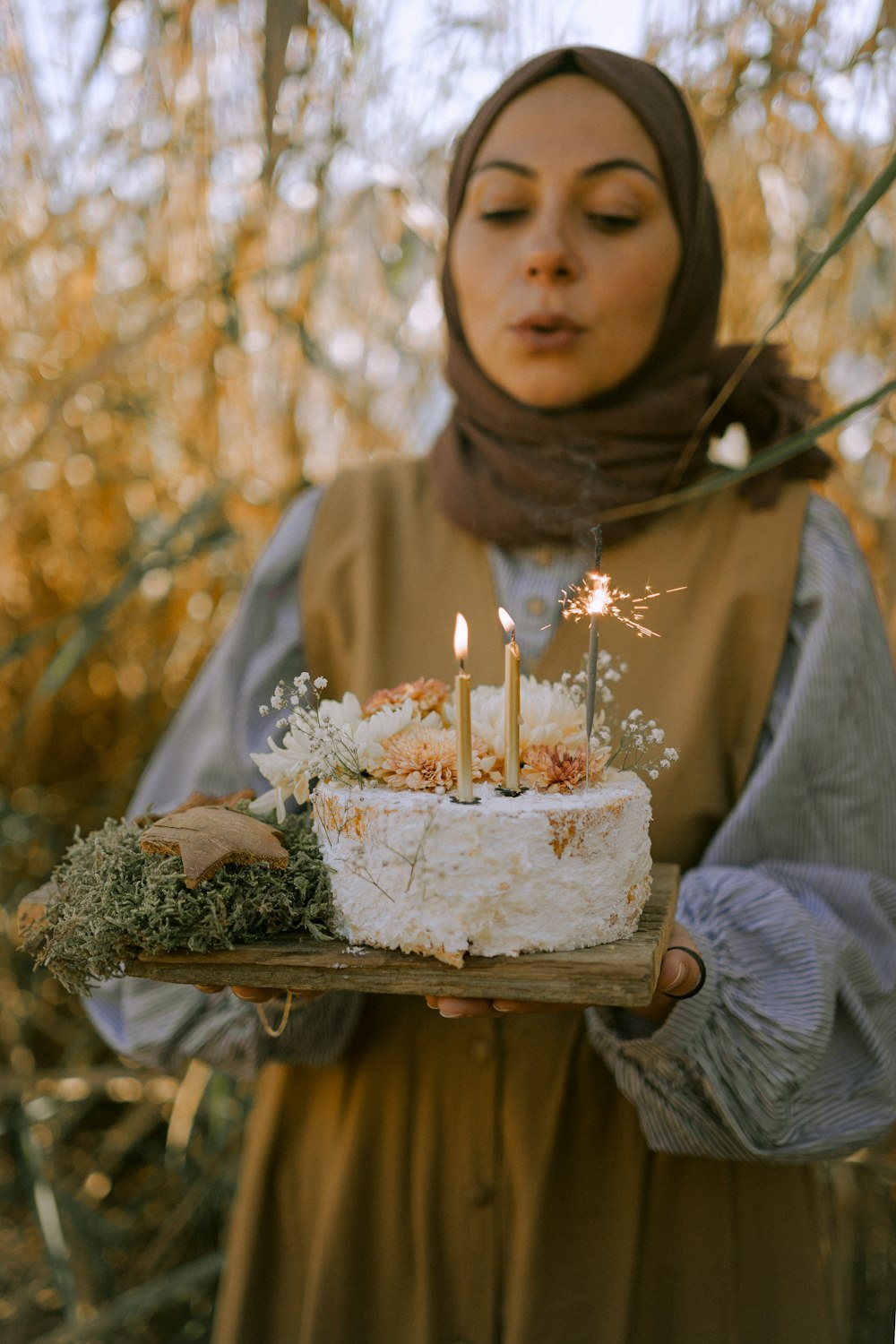 una mujer sosteniendo un pastel con velas