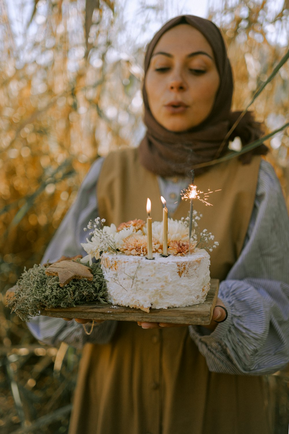 a woman holding a cake with candles on it