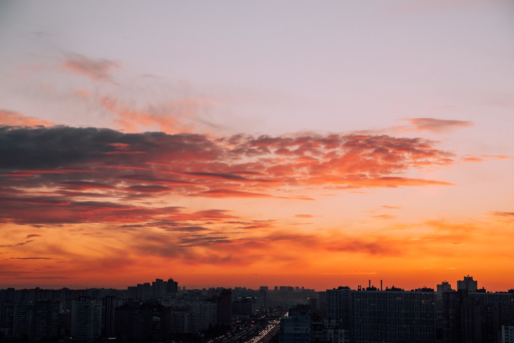 a sunset over a city with tall buildings