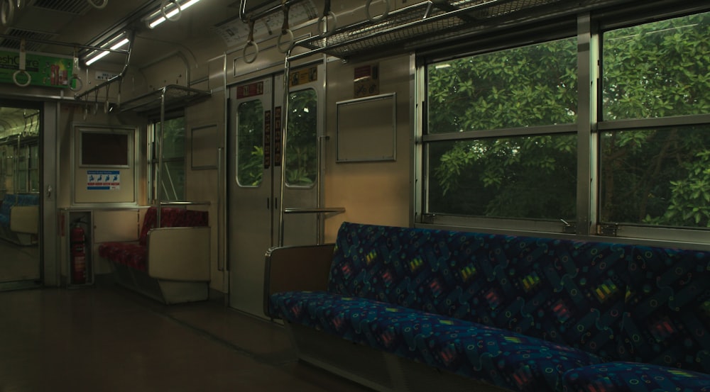 a train car with a blue seat and trees in the background