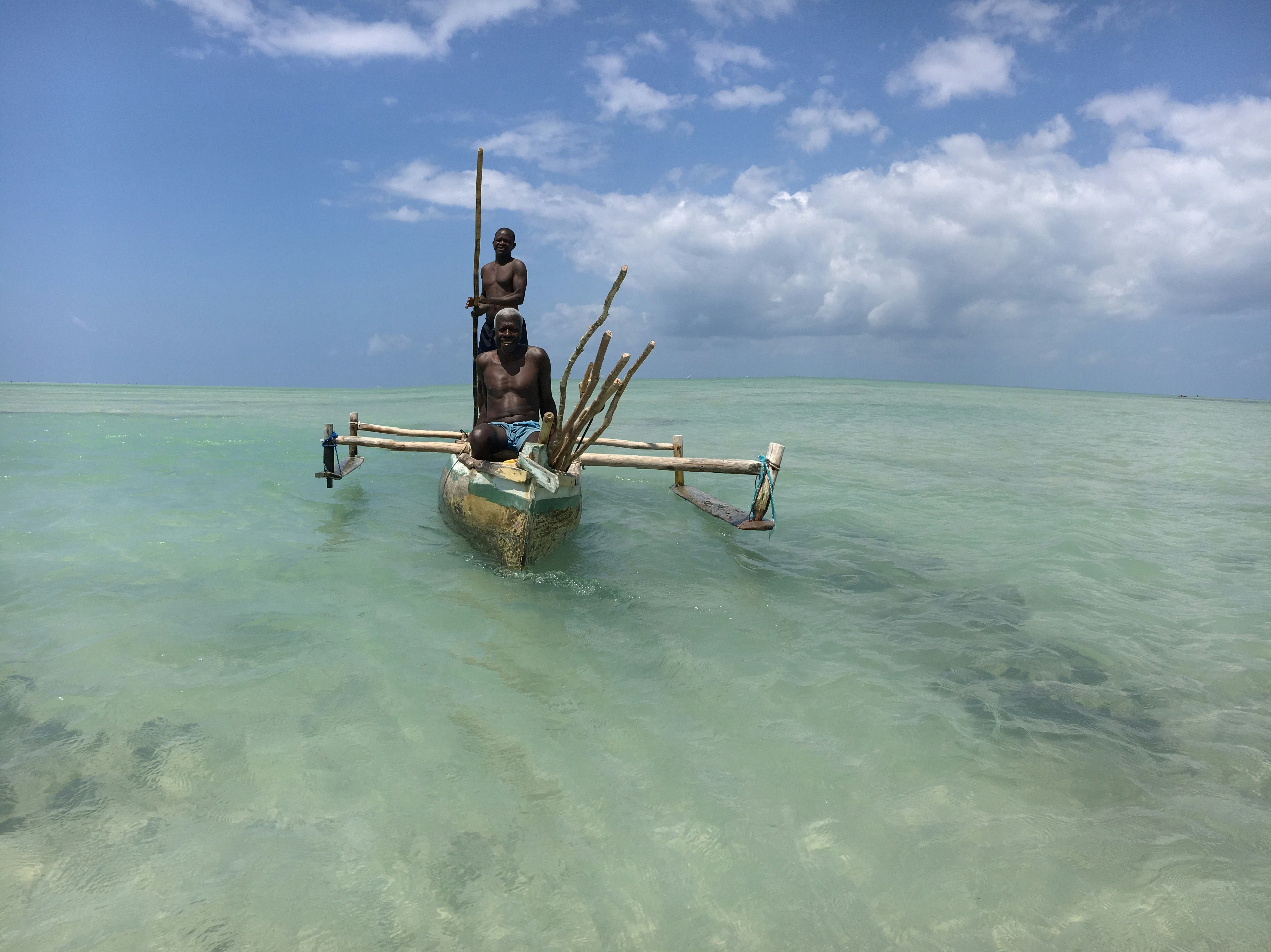 Traditional Polynesian navigator on outrigger canoe using stars and ocean swells for navigation