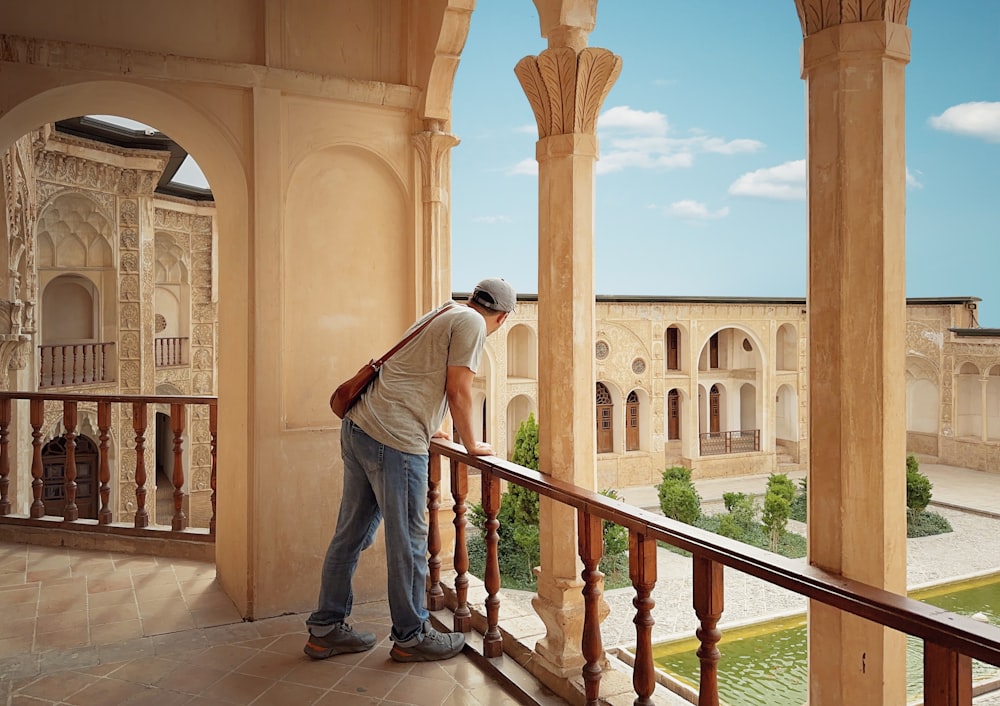 a man standing on a balcony next to a building