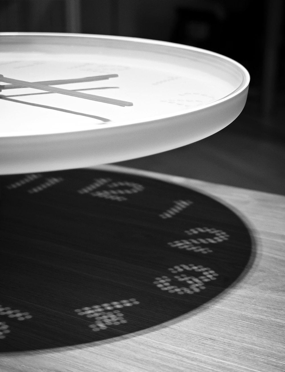 a white clock sitting on top of a wooden table