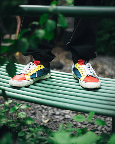 Pair of colorful rubber shoes displayed on a bright outdoor bench