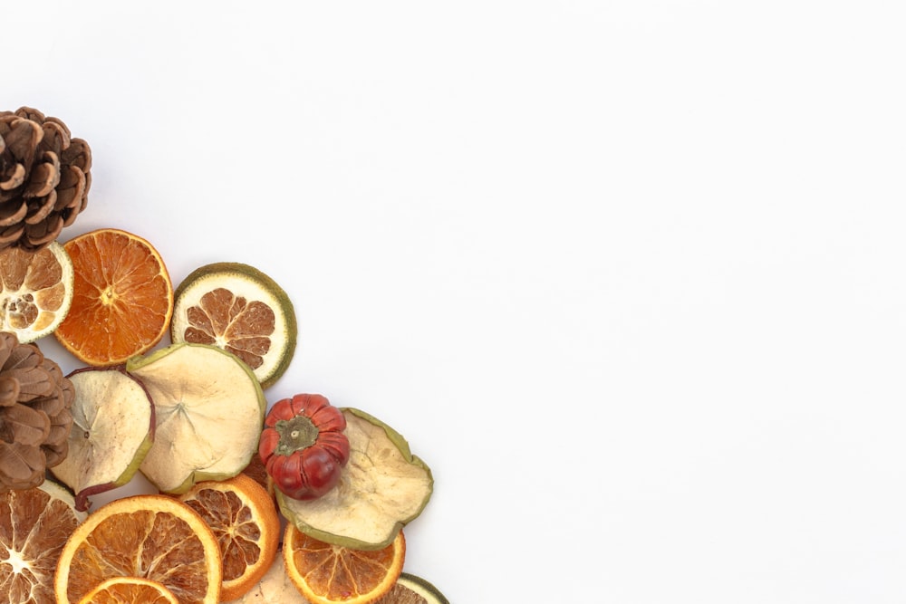 a pile of sliced oranges and pine cones