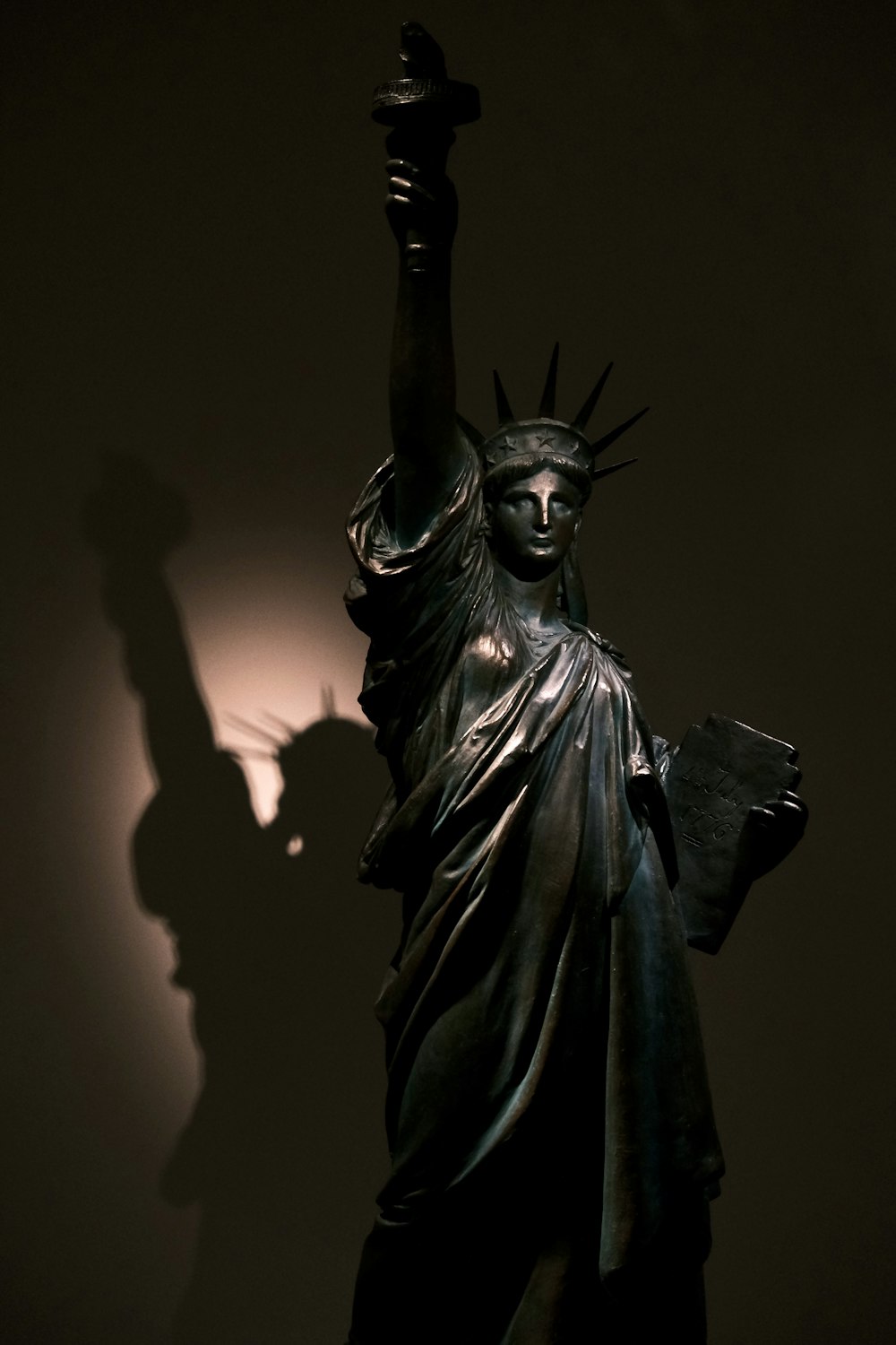 the statue of liberty is casting a shadow on the wall