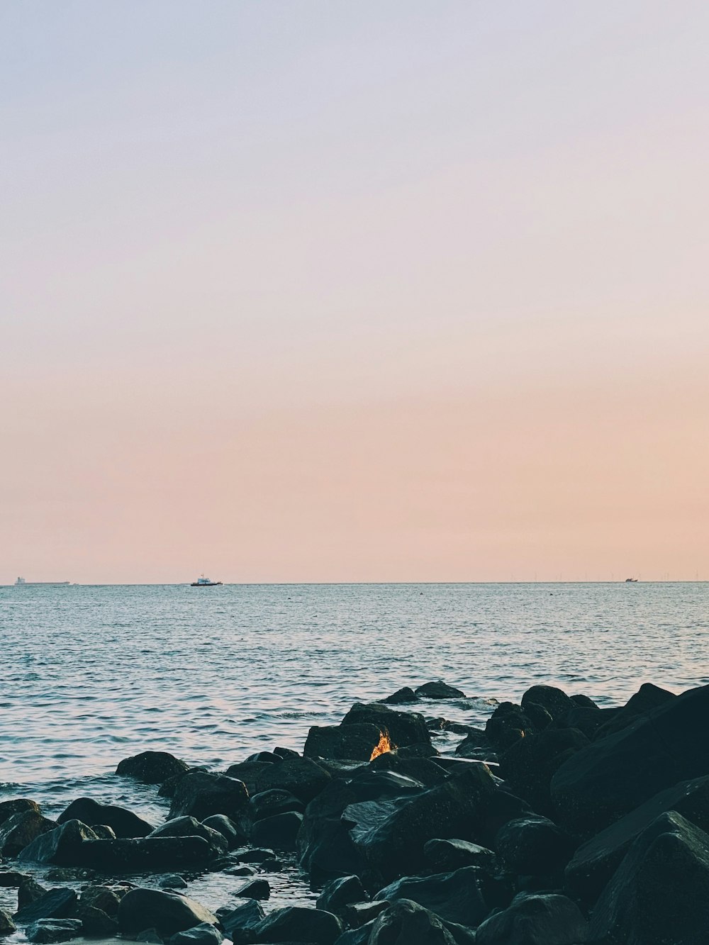 a person standing on rocks near the ocean