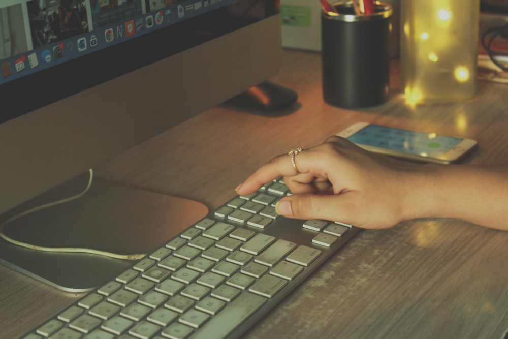 a person typing on a keyboard on a desk