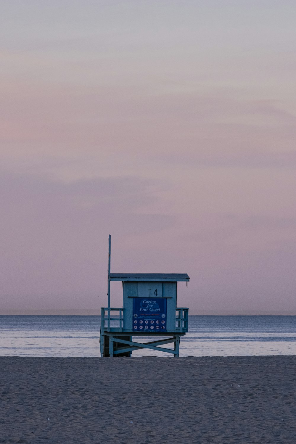 a lifeguard stand on the beach at sunset