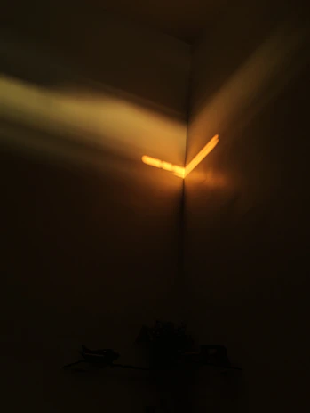 A golden aperture-shaped light softly illuminating a dark room filled with storyboards and creative notes.