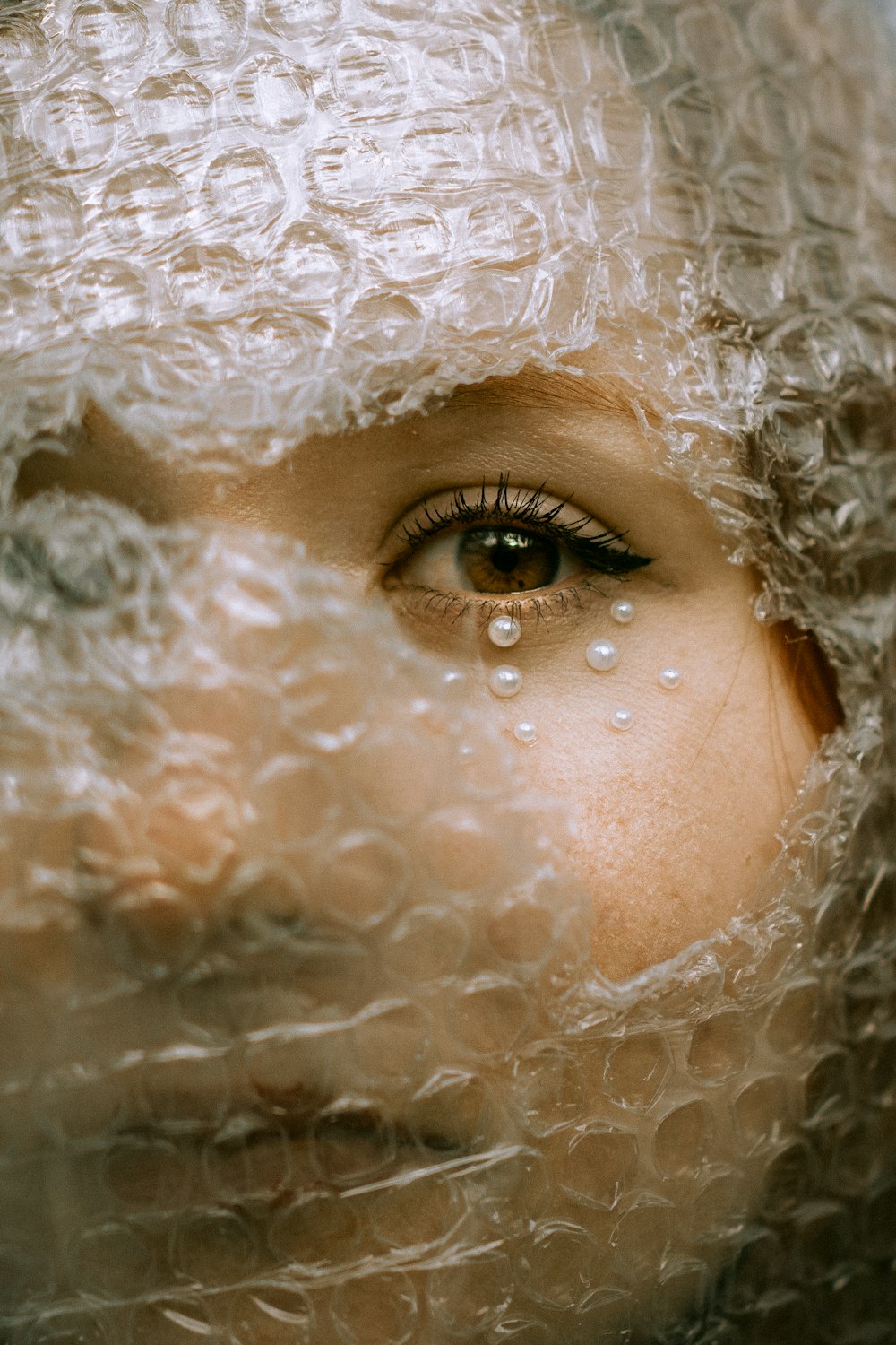 a close up of a woman's face covered in plastic