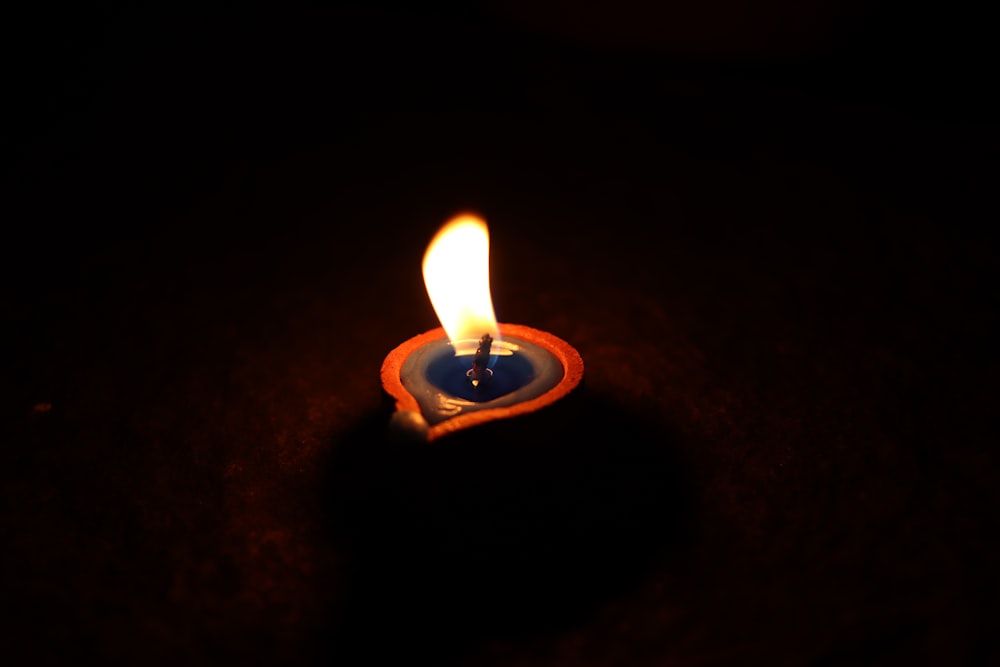 a lit candle sitting on top of a table