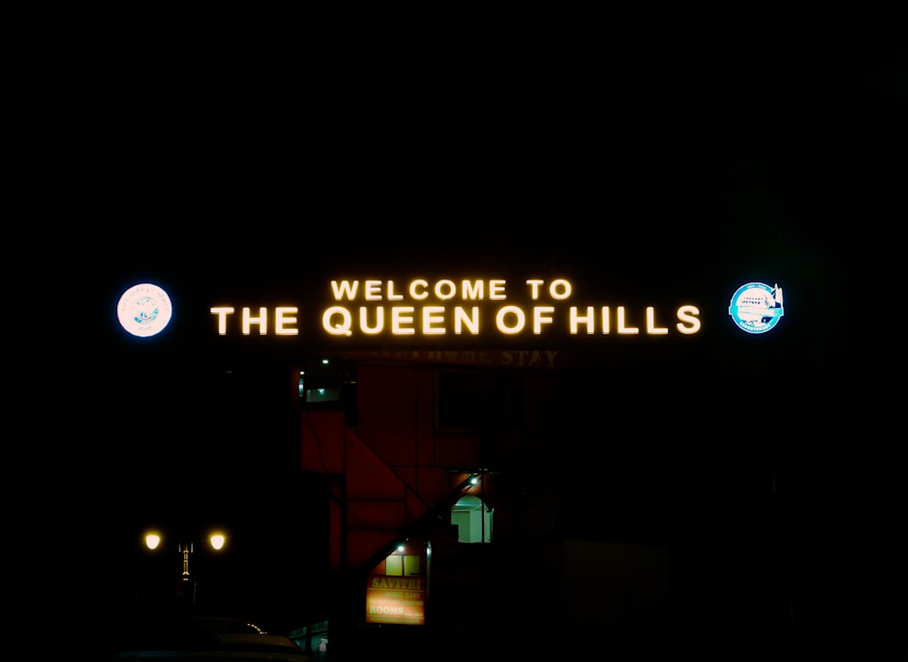 a neon sign that reads welcome to the queen of hills