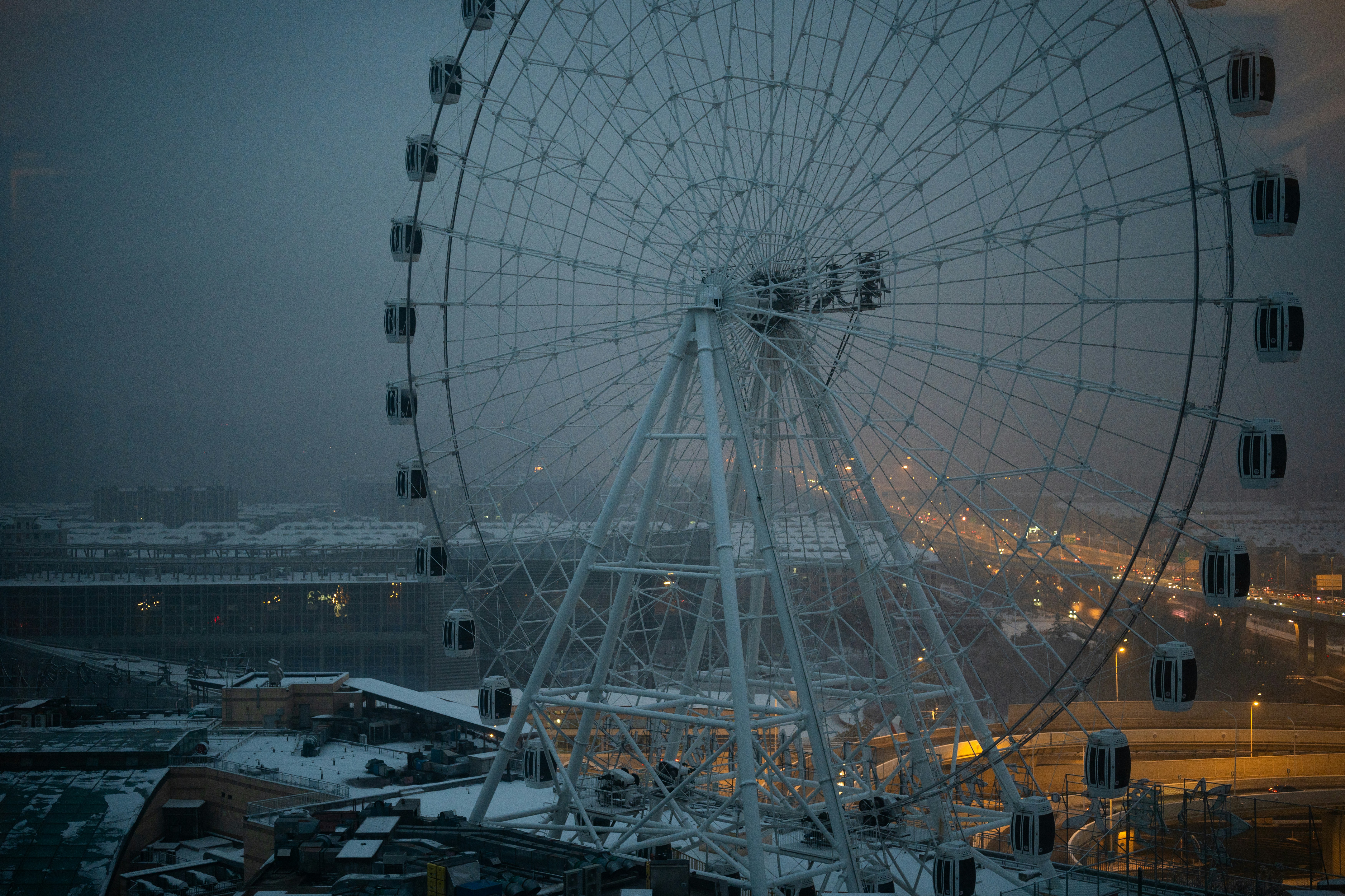 Riesenrad vor einer nebligen, dämmerlichen Stadtlandschaft